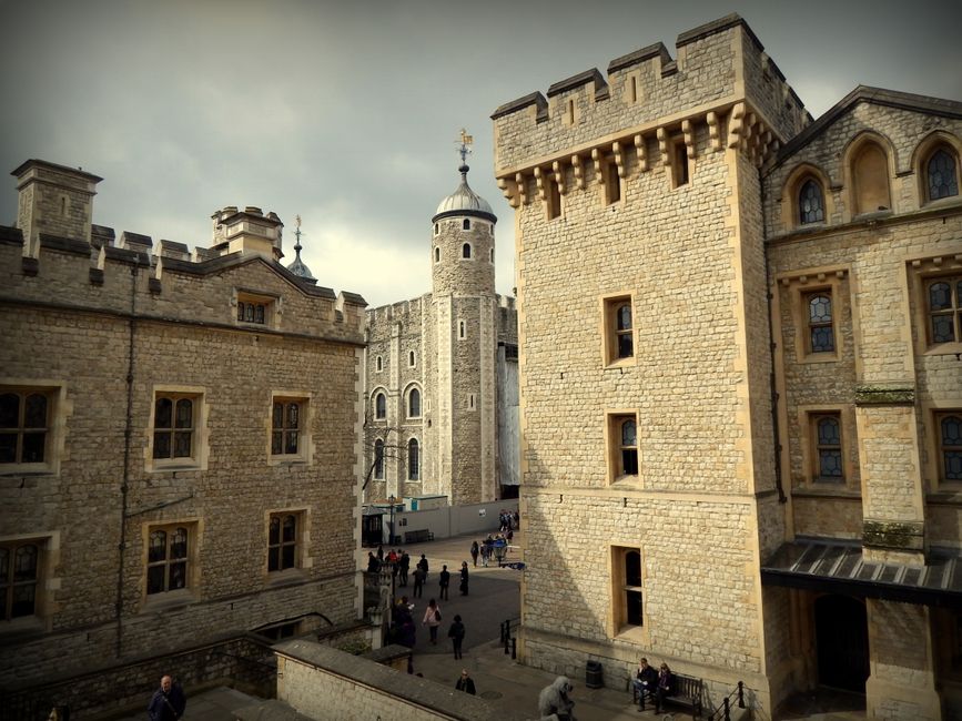 View of the historic Tower of London with stone walls and turrets, popular tourist destination.