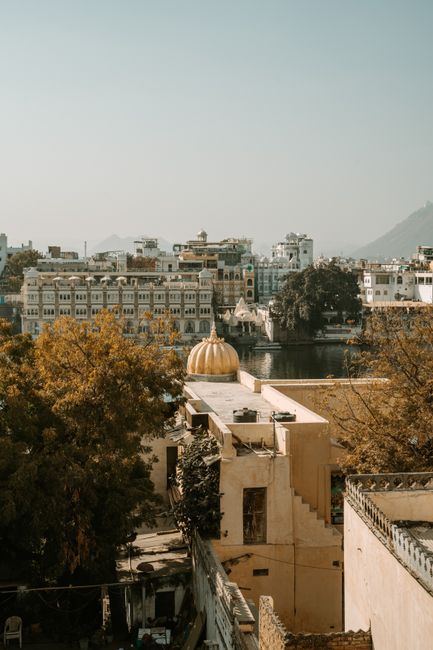 A picturesque view of Udaipur city with traditional architecture and a tranquil lake.