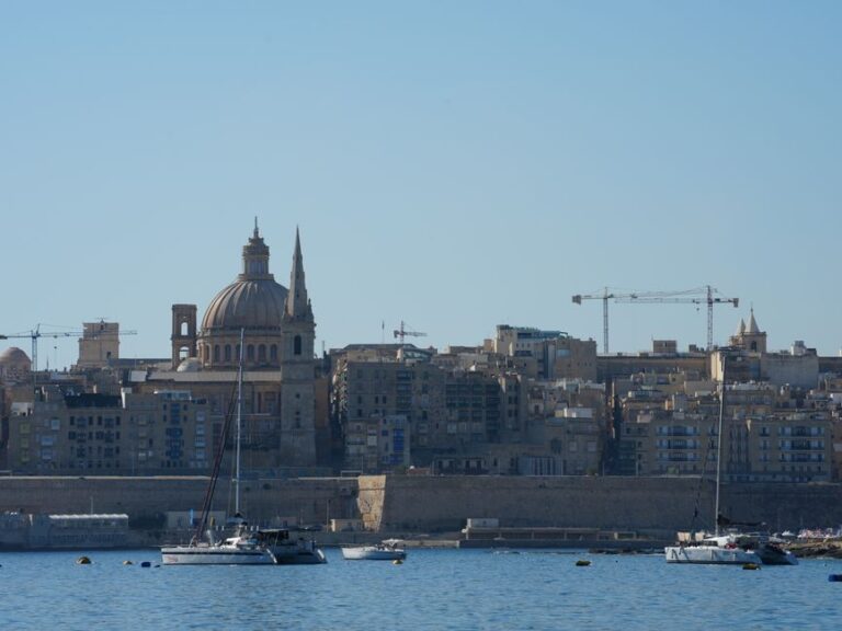 Beautiful view of Valletta with boats in foreground, highlighting iconic architecture under a clear blue sky.