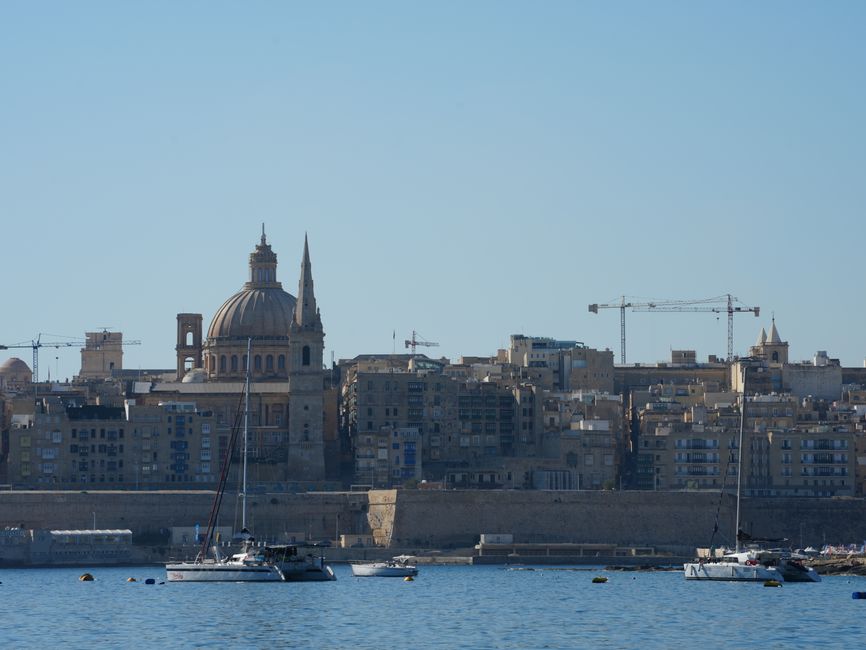 Beautiful view of Valletta with boats in foreground, highlighting iconic architecture under a clear blue sky.