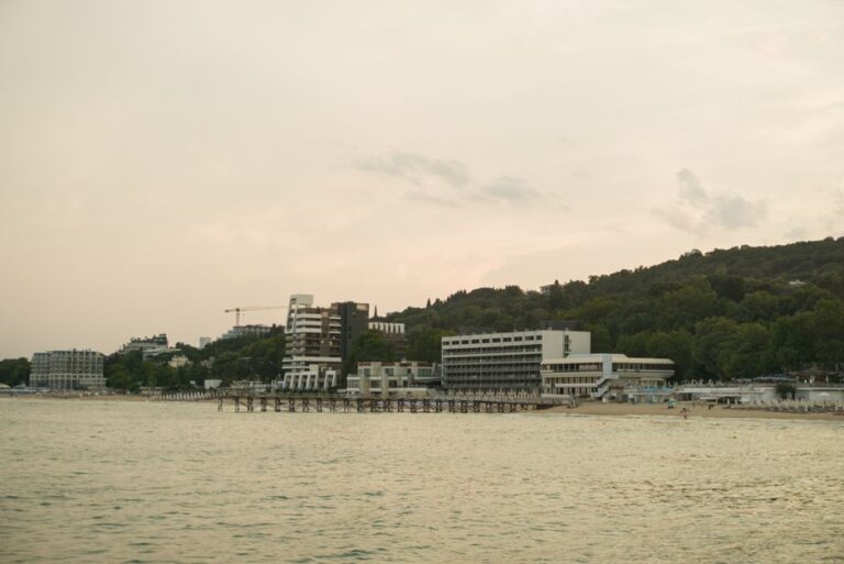 Scenic view of Varna's coastline with beachfront buildings during sunset, showcasing a tranquil summer evening.