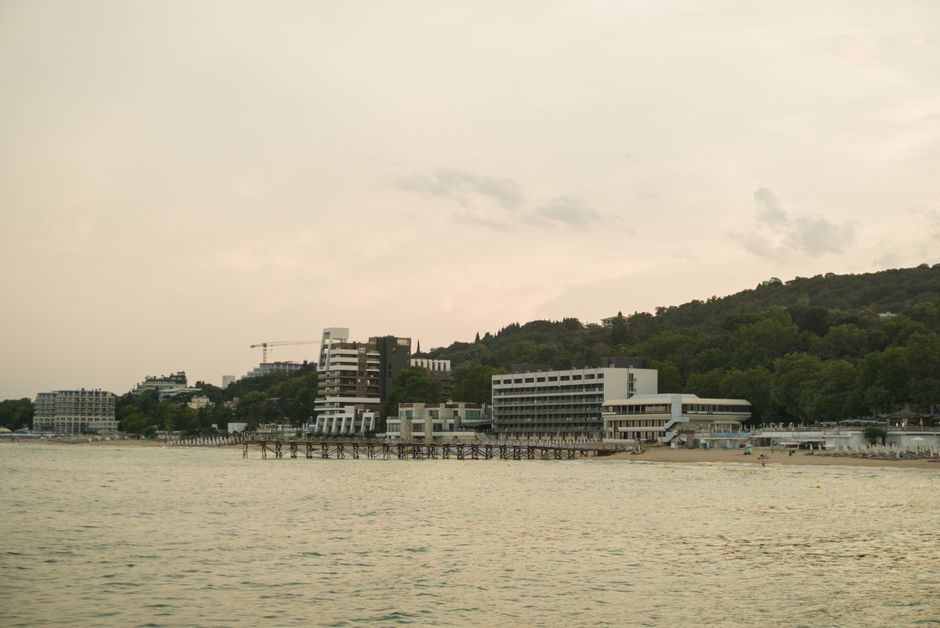 Scenic view of Varna's coastline with beachfront buildings during sunset, showcasing a tranquil summer evening.