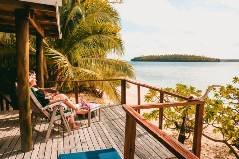 A serene tropical deck overlooking a scenic beach, perfect for relaxation and vacation vibes.
