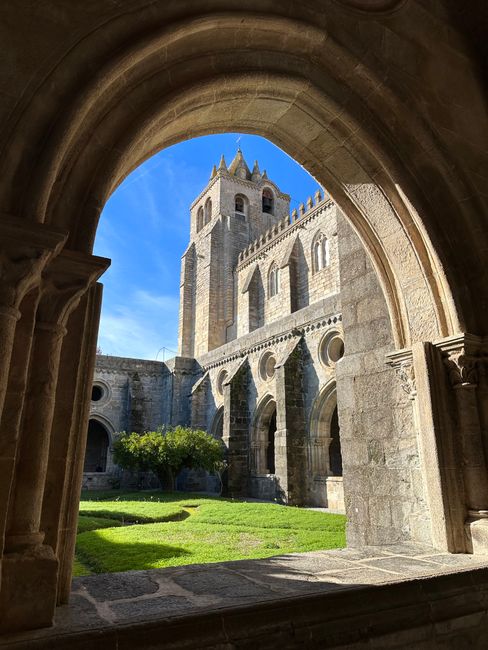 Explore the majestic Gothic architecture of Évora Cathedral in a sunny courtyard view.