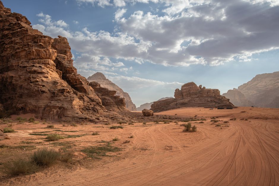 Scenic desert landscape with rock formations and cloudy sky in Wadi Rum, Jordan.