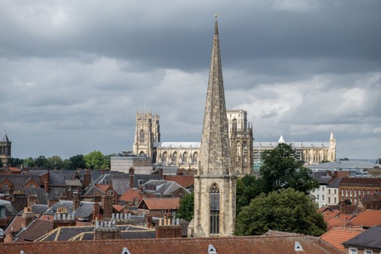 Scenic view of York with prominent cathedral spires under cloudy skies.